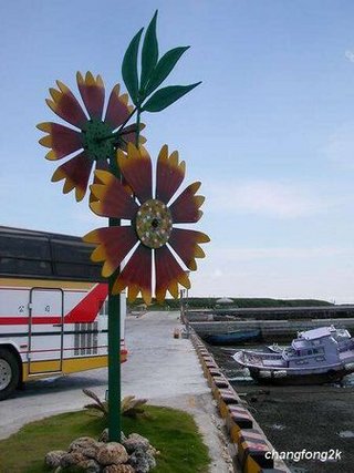 風車在這幾年成為澎湖造景藝術主要的題材，大街小巷都可以看得到風車的裝置藝術，這是在跨海大橋旁的風車圖騰，澎湖嘛！風的故鄉！